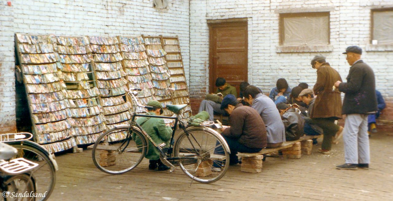 Streetside readers in Xian. This I believe was a public library of sorts. People would come here and read the books and magazines from the racks. China - Xian
